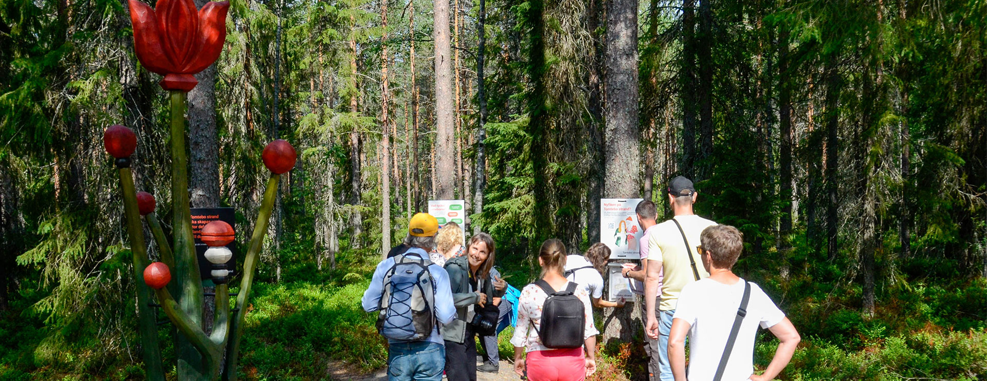En samling personer i skogen vid Tomtebo strands Dialogplats