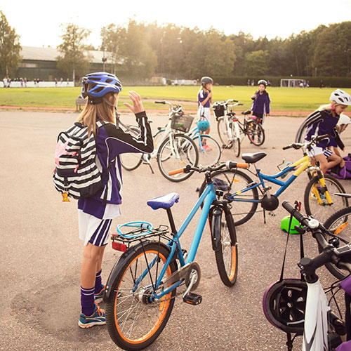 A group of children is standing with their bicycles.